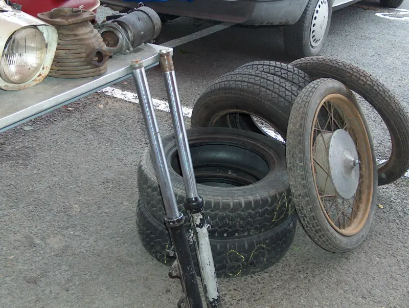 Régi motoralkatrészek, gumiabroncsok és kerekek kiállítva a Budaörsi Virágpiaci Börzén, 2005 októberében.