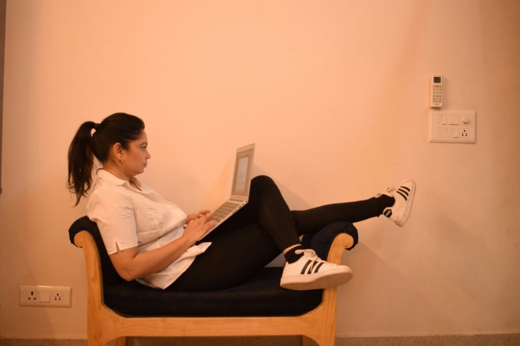 Young woman studying on a laptop in a relaxed position at home – showing Vig-Village’s comfortable learning style