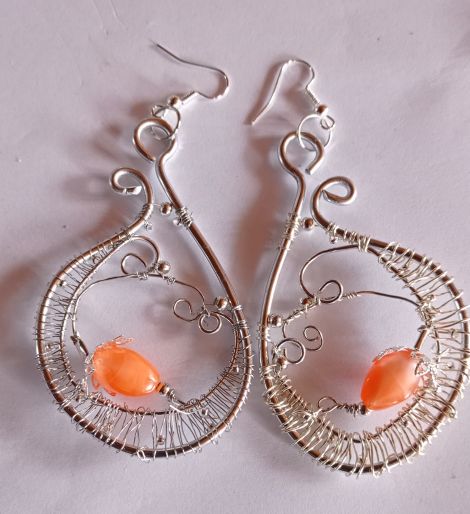 Earrings handcrafted with silver-colored wire and orange beads – made by the site author