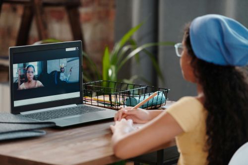 A student participating in a video call with a native English teacher and a speaking partner — illustrating the Vig-Village method