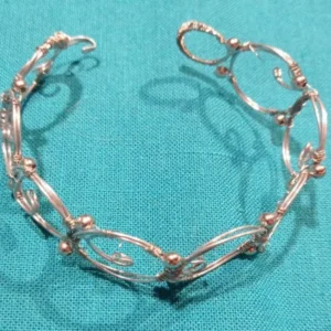 This bracelet is made with a special wire-working technique. It is hand-shaped and decorated with tiny metal beads. A one-of-a-kind piece.