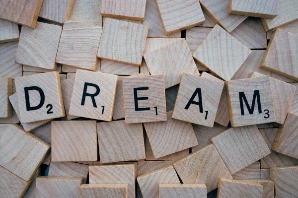 Fa betűkockákból kirakott szó: DREAM – az álmodás erejének szimbóluma
