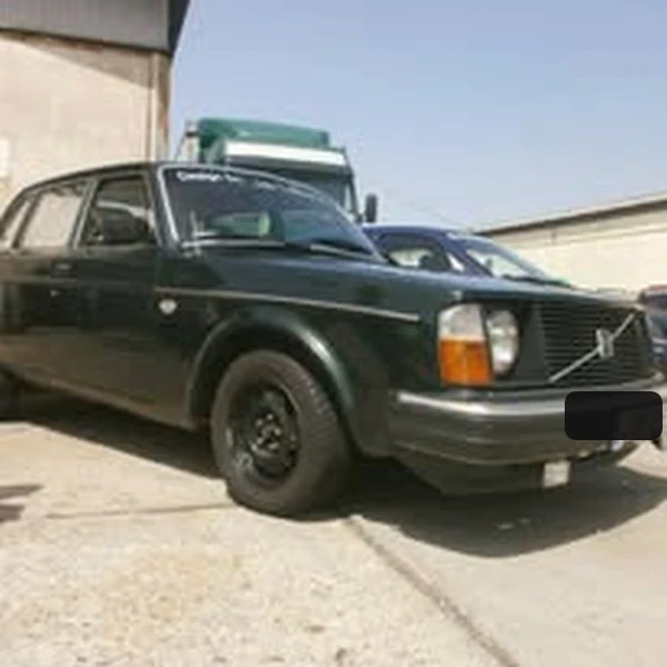 An old dark green Volvo car parked in a courtyard, shown while it was still in working condition.