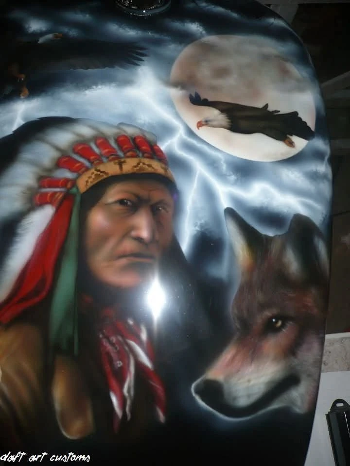 Airbrushed tank painting featuring a Native American man in a feathered headdress, a wolf, and a flying eagle with a full moon in the backgroun