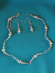 Elegant jewelry set with shiny metal beads and handcrafted wire links. Tightly fitting necklace and earrings for festive occasions.