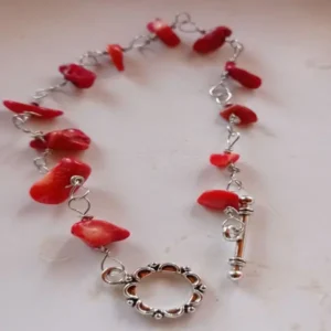 Red gemstone bracelet, wire-wrapped connections. Handmade, one-of-a-kind piece crafted from natural, irregular-shaped red gemstone beads. The beads are connected with silver-colored wire using a loop-wrapping technique. Finished with a decorative toggle clasp. Length: approx. 18 cm