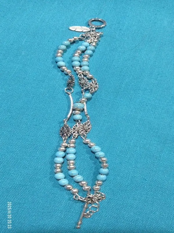 Three-strand turquoise bracelet with floral metal accents