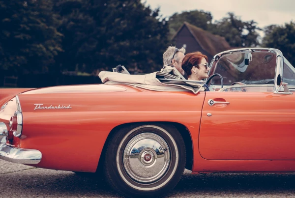 Elderly couple in a red convertible – symbol of energy and explosiveness