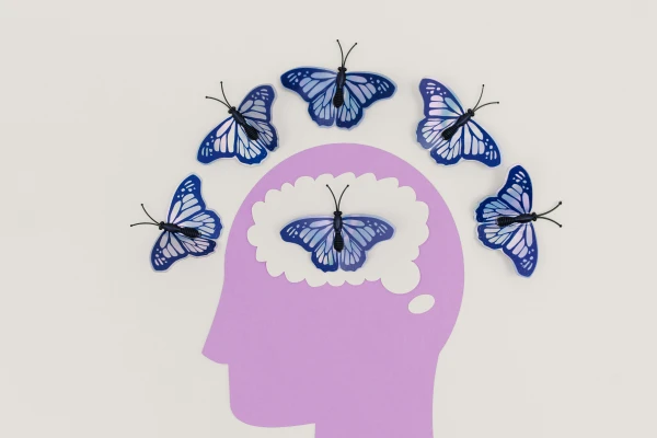 Pink head silhouette with butterflies – symbol of positive transformation in thinking