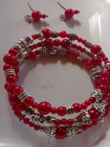 Three-loop red beaded bracelet with silver accents and matching red earrings.