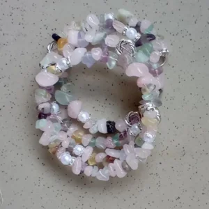 Four-loop memory wire bracelet with rose quartz and colorful gemstones, accented with spiral metal rings and white beads.