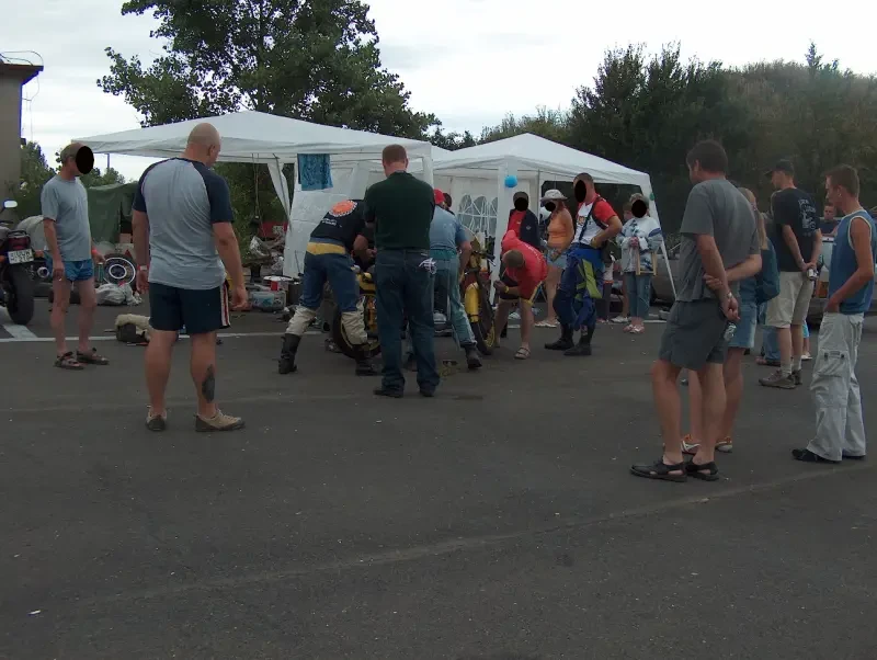Many people repair motorcycles in front of their tents.