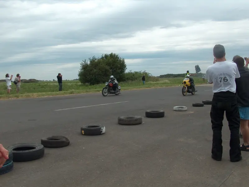 Kunmadarasi 24 órás motorverseny cél vonala. 2 motor már beért. De nem ők voltak az elsők. Közelről, és távolról is emberek fotózzák őket.