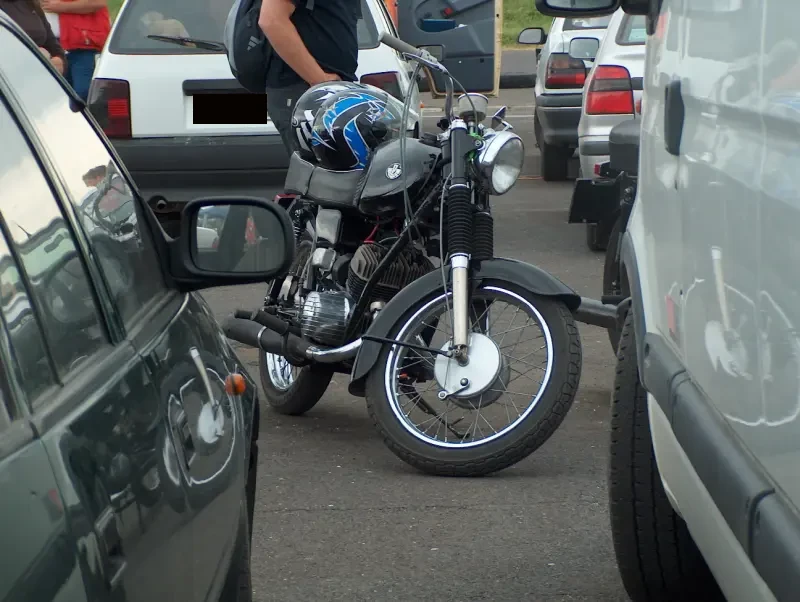 Autók között egy fekete motorkerékpár