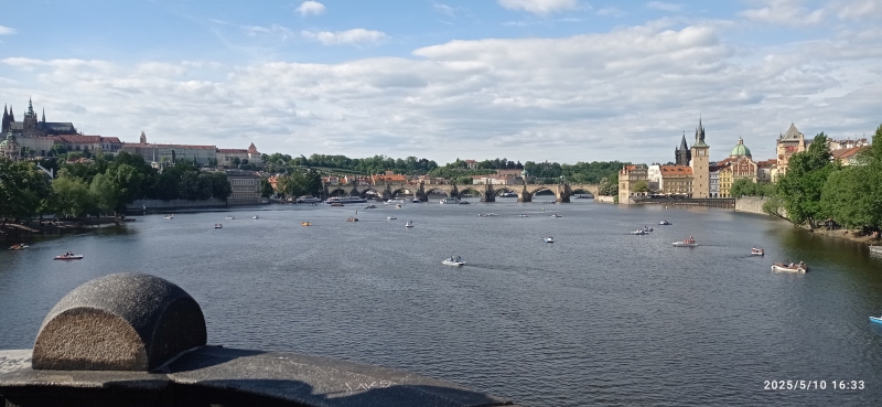 I took this photo from a bridge in Prague during my travels abroad. Here you can see the Vltava River with the sights of the Old Town in the background and several boats in the foreground. In the lower left corner of the photo, there is a stone half-barrel lying on its side.