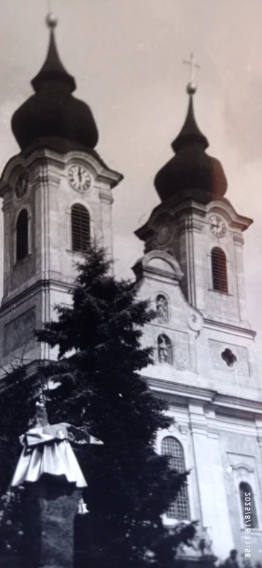Bellföldi utazásaim kapcsán Tihanyban készítettem az apátságról ezt a fotót. Két temlomtorony előtt a magas fenyőfa áll. Bal alsó raokban egy fém non-figurativ szobor magas talapzaton. 