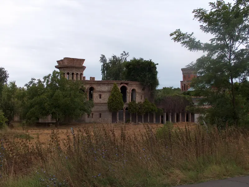 Téglaépítésű, romos villa épület növényzettel körülvéve