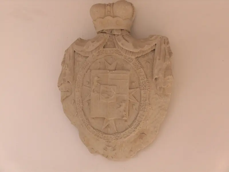 Decorative carved stone coat of arms with crown motif at Sárospatak Castle.”