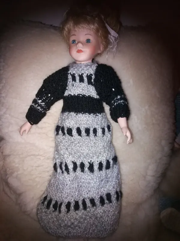Toy doll in a gray and black knitted dress