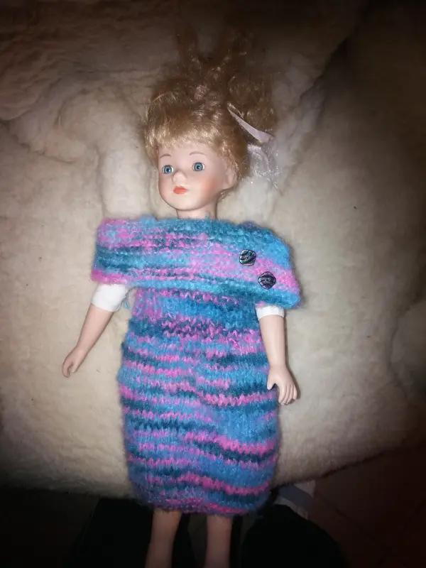 Doll in purple and blue knitted dress