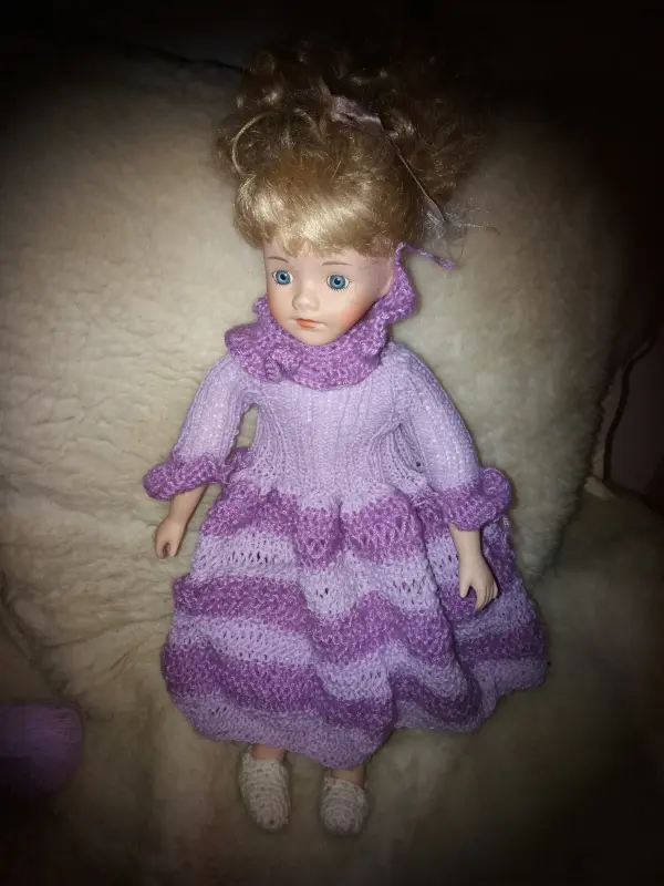 Toy doll in purple knitted dress
