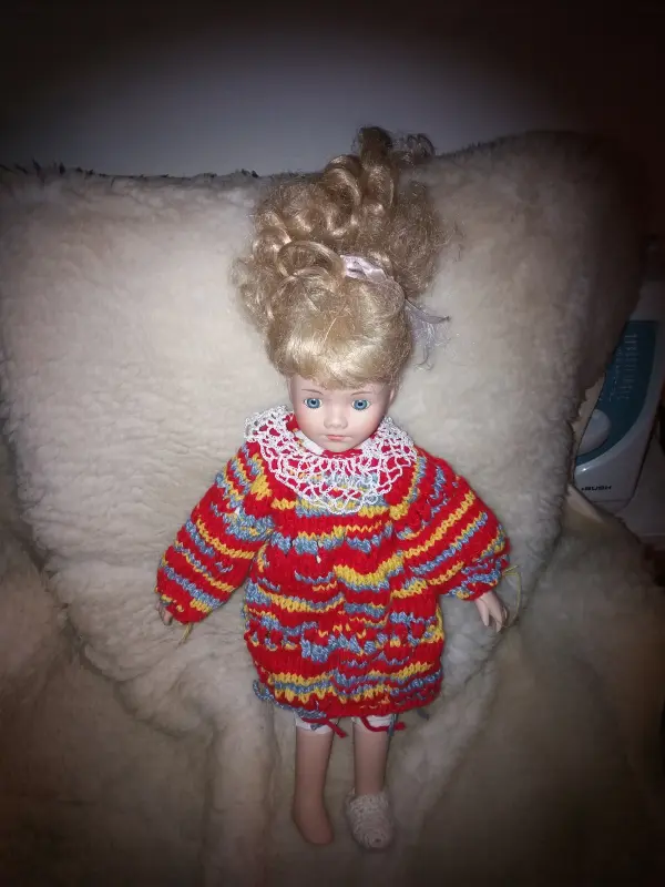 Toy doll in red and yellow knitted dress